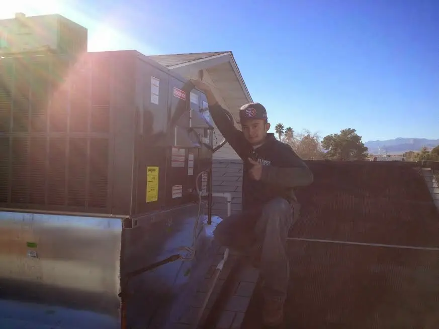 HVAC technician performing Air Duct Cleaning on a rooftop unit in Patton