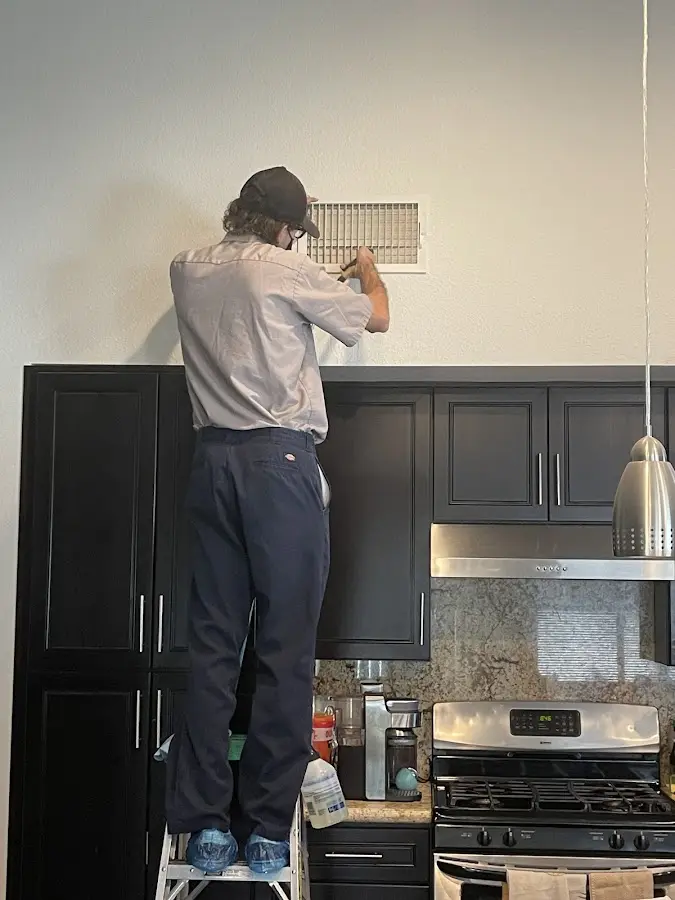 Technician inspecting an air vent during HVAC service in Patton